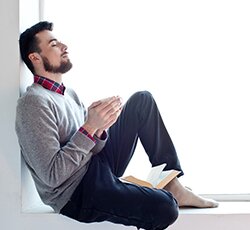 man relaxing by window