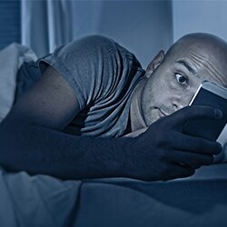 addicted-to-smartphone-internet-man-in-bed-at-night